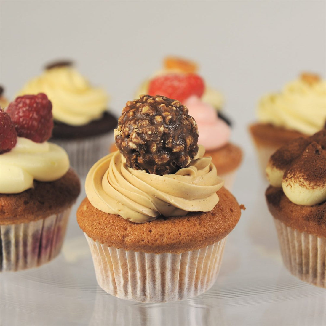 Close up of a selection of beautifully decorated Italian cupcakes, showcasing a variety of flavours with toppings and frosting made by Biscotti di Debora of Cambridge.