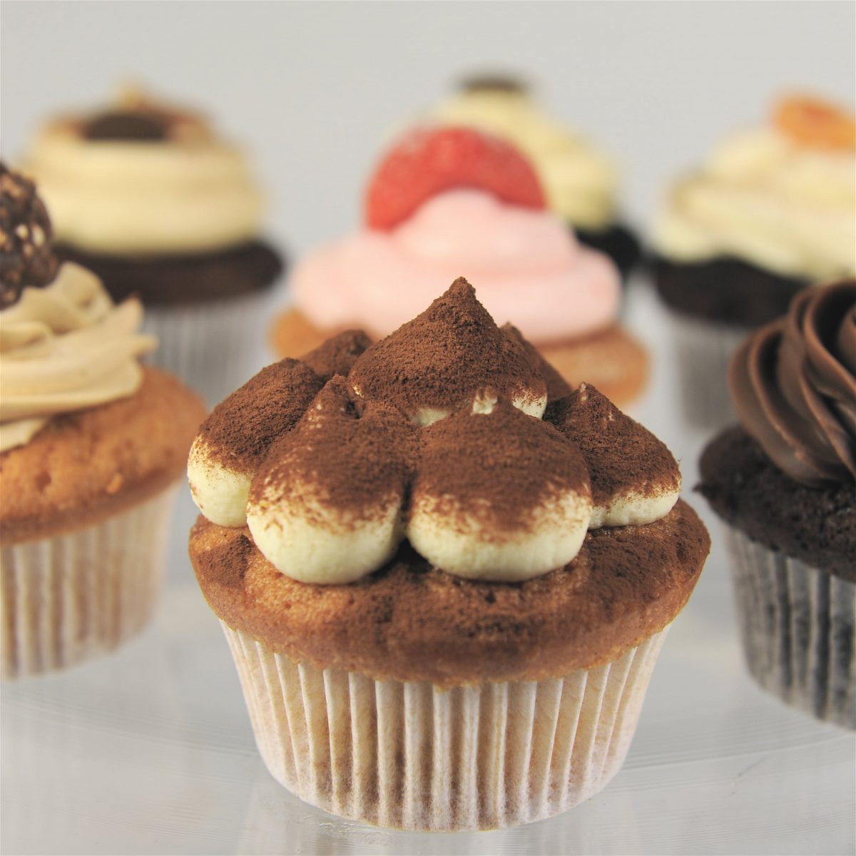 Close up of a selection of beautifully decorated cupcakes with tranditional Italian flavours and frosting made by Biscotti di Debora of Cambridge.
