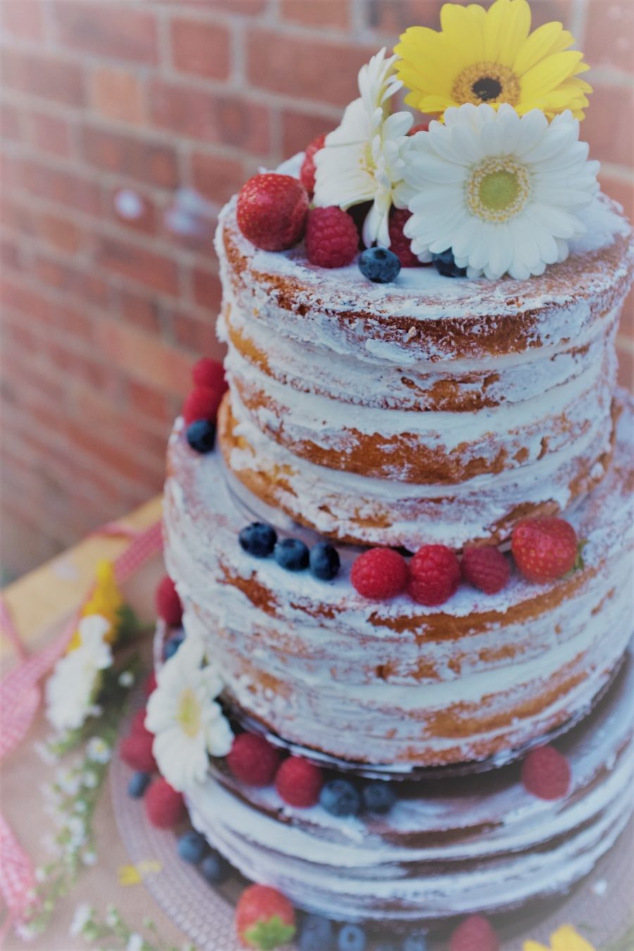 A Naked Tiered Wedding Cake with Floral decoations